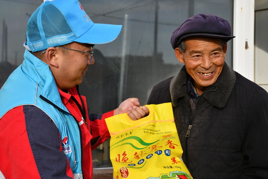 黨員突擊隊(duì)隊(duì)員正在將慰問品發(fā)給貧困老人 攝影:溫馨.JPG